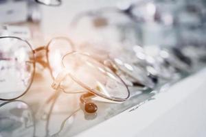 Eye glasses on window display shelves in optics store photo