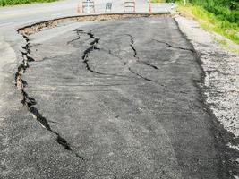 asphalt road cracked and broken texture photo