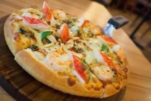 Delicious seafood pizza on wooden table photo