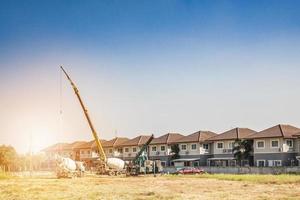 House building at construction site with crane truck photo