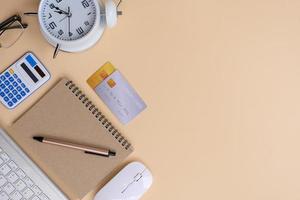 Office desk with smartphone, laptop computer, cup of coffee, and office tools. Flat lay, top view with copy space. A bank notepad and a pen are on top of an office desk table containing computer tools photo