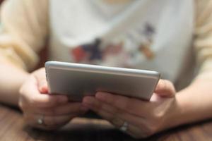 closeup woman hands using tablet computer on wooden table photo