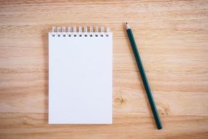 Pencil and Notepad on the wooden desk photo