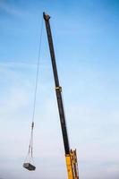 mobile construction crane truck lifting concrete slab to building house at construction site photo