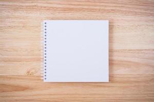 white cover notebook on brown wood desk background photo