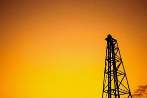 Silhouette pile driver at construction site photo