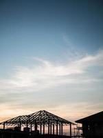 edificio de la casa de la silueta en el fondo de la puesta del sol del sitio de construcción foto