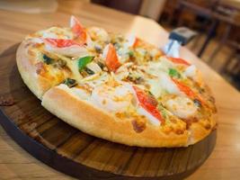 Delicious seafood pizza on wooden table photo