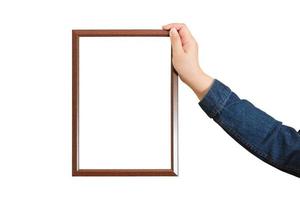 A blank diploma or a mockup certificate in the hand of a woman employee wearing a denim shirt on white background with a clipping path. The The vertical picture frame is empty and the copy space. photo