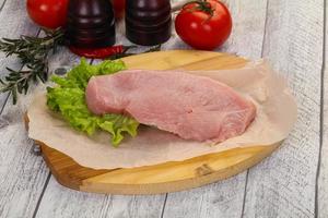 Raw Turkey steak served rosemary photo