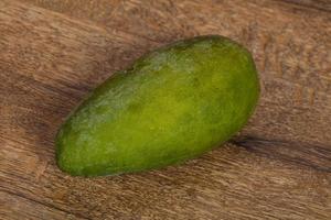 Green tasty mango over wooden background photo