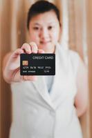The right hand of a white woman showing a mock-up credit card for shopping. selective focus. photo