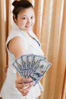 The right hand of a white woman showing a mock-up hundred-dollar banknote for shopping. selective focus. photo