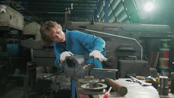 una joven ingeniera profesional de la industria trabaja con un uniforme de seguridad con herramientas de precisión de metalistería, tornos mecánicos y taller de piezas de repuesto en la fábrica de acero. video