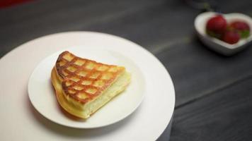 waffles belgas com morangos e café em uma mesa de madeira escura. video