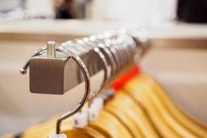 Close up clothes hanging on rack in boutique store photo