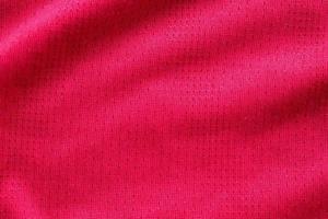 Red fabric sport clothing football jersey with air mesh texture background photo