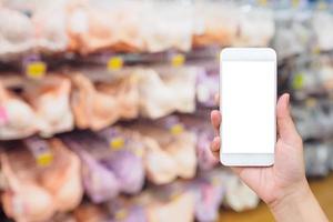 Woman hand holding mobile smart phone with bras on stand in store photo