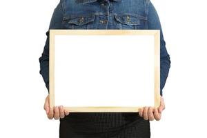 A blank diploma or a mockup certificate in the hand of a woman employee wearing a denim shirt on white background with a clipping path. The horizontal picture frame is empty and the copy space. photo