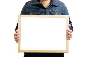 A blank diploma or a mockup certificate in the hand of a woman employee wearing a denim shirt on white background with a clipping path. The horizontal picture frame is empty and the copy space. photo