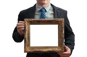 blank diploma or a mockup certificate in the hand of a male employee wearing a black suit on white background with a clipping path. The horizontal picture frame is empty and the copy space. photo