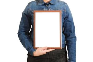 A blank diploma or a mockup certificate in the hand of a woman employee wearing a denim shirt on white background with a clipping path. The horizontal picture frame is empty and the copy space. photo