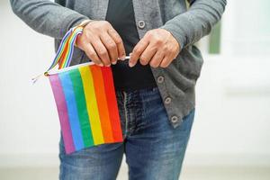 Asian woman with rainbow flag, LGBT symbol rights and gender equality, LGBT Pride Month in June. photo