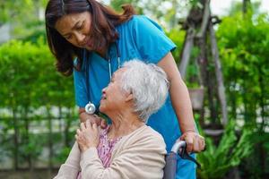 Asian elderly woman disability patient sitting on wheelchair in park, medical concept. photo