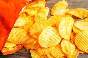 Potato chips in open bag, delicious BBQ seasoning spicy for crips, thin slice deep fried snack fast food. photo