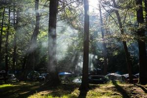 Sun rising in a forest camp with tents photo