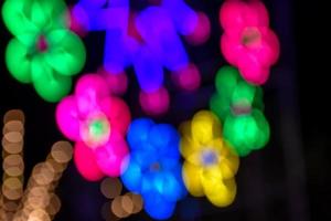 luces nocturnas y bokeh del paseo del parque de diversiones foto