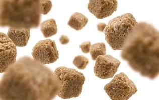 Brown cane sugar levitates on a white background photo