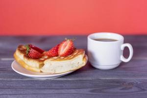 gofres belgas con fresas y café en una mesa oscura de madera. foto