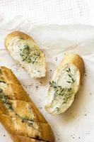 French baguettes and cut slice with thyme on kraft paper. Top view food, close up photo