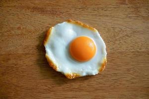 top view of fried eggs isolated on wooden background photo