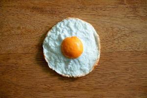 top view of fried eggs isolated on wooden background photo