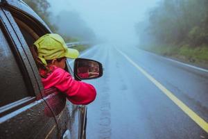 las mujeres asiáticas viajan relajarse en las vacaciones. conduciendo un coche viajando feliz. en medio de la neblina lluviosa. foto