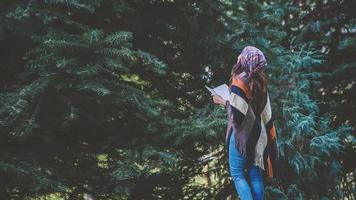 Young woman relax in the holiday. Travel nature and  write a note Happy to see the beauty of the pine leaf. Nature Study. photo