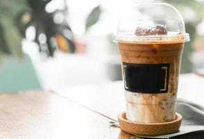 Iced coffee on wooden table at cafe photo