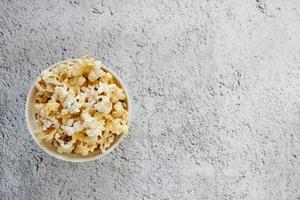 Spilled popcorn and paper bucket on background. Movie night concept. Copy space for text photo