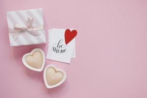 feliz composición del día de san valentín. maqueta de tarjeta de felicitación en blanco sobre fondo rosa foto