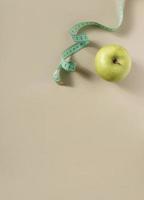 Diet concept. Apple with measuring tape photo