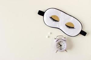 Flat lay composition with sleep eye mask, dream book and alarm clock on background. Healthy sleeping concept. photo