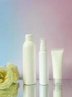 Mockup white plastic tube for moisturizer, lotion, facial cleanser or shampoo on smudged cream. photo