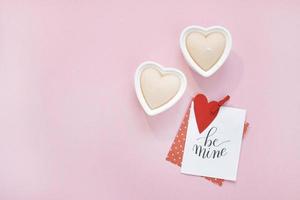Happy Valentines Day composition. Blank greeting card mockup, gift boxes, red hearts, confetti on pink background photo