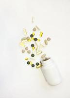 Vitamin tablets. Bottle with colored pills on background. Multivitamins. photo
