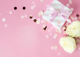 cajas de regalo y flores rosas sobre fondo rosa. feliz día de san valentín, día de la madre, concepto de cumpleaños. composición romántica plana. foto