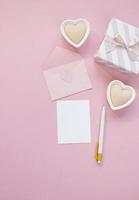 Happy Valentines Day composition. Blank greeting card mockup, gift boxes, hearts, confetti on pink background photo
