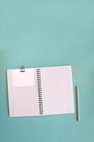 Blank notebook for writing on spirals on a blue background, flat lay, the end of motivation, business, building goals with negative industrial space and copy space photo