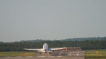 Commercial aircraft takes off, rear view. View of the airfield, airport runway. Passenger airplane departure. Tourism and aviation concept video